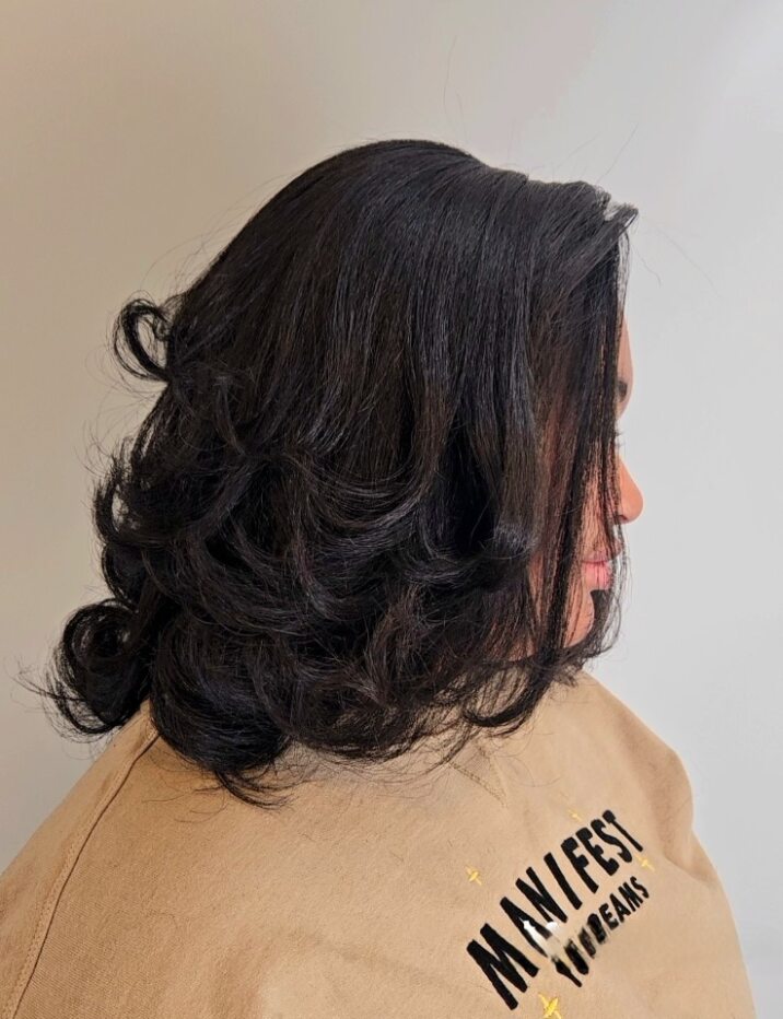 The back of a woman's head wearing a tan jacket