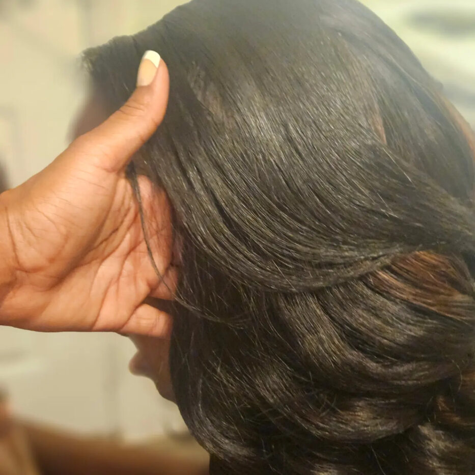 A close up of a person holding their hair