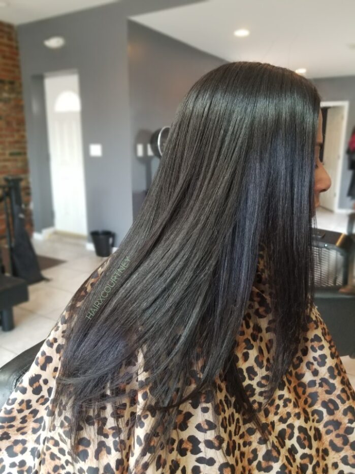 A woman with long black hair in a salon